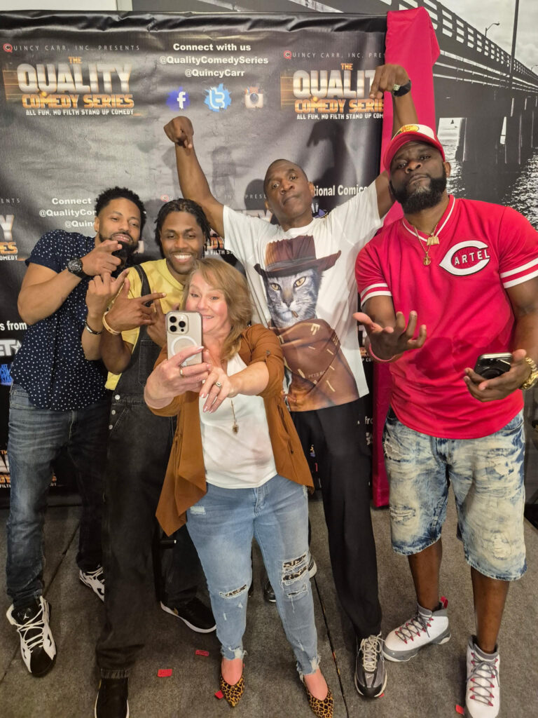 A group of five comedians posing for a selfie at the Quality Comedy Series event, showcasing a fun and lively atmosphere.